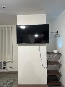 a flat screen tv on top of a white wall at Condo in Ortigas in Manila