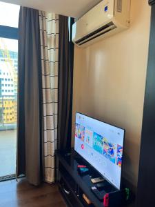 a flat screen tv in a room with a window at Appleone Ayala Condo with Balcony in Cebu City