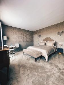1 dormitorio con 1 cama grande y 1 mesa en Le Château d Hardricourt, en Hardricourt