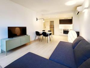 ein Wohnzimmer mit einem Sofa und einem Tisch mit Stühlen in der Unterkunft Moderno Apartamento en Terrassa Centro in Terrassa