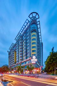 Un edificio alto con le montagne russe sopra. di Insail Hotels (Pazhou Exhibition Center KeCun Metro Station Dunhe Road Branch Guangzhou) a Canton