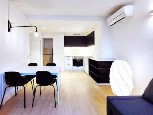 eine Küche und ein Wohnzimmer mit einem Tisch und Stühlen in der Unterkunft Moderno Apartamento en Terrassa Centro in Terrassa