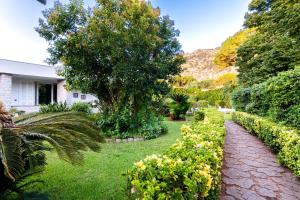 a garden with bushes and a brick path at Mondello luxury villa con piscina in Mondello