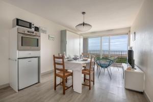 a kitchen and dining room with a table and chairs at St Brévin - Studio - 4 Pers - Vue Mer in LʼErmitage