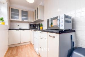 a kitchen with white cabinets and a microwave at Cosy 1-bed Annexe in West Bridgford, Nottingham by Renzo, Free Driveway Parking! in Nottingham