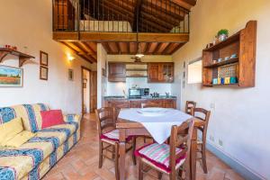 een woonkamer met een tafel en een bank bij Borgo Dolci Colline Resort Granaio in Castiglion Fiorentino