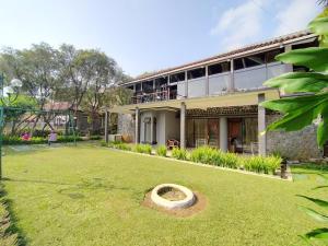een gebouw met een grote tuin ervoor bij Villa Bukit Danau Lot 14 in Cinengangirang