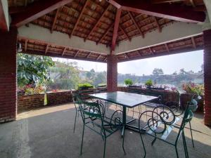 een tafel en stoelen op een patio bij Villa Bukit Danau Lot 14 in Cinengangirang