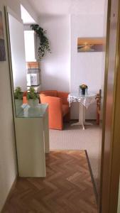ein Wohnzimmer mit einem orangenen Sofa und einem Tisch in der Unterkunft Seemöwe Wohnung in Rostock