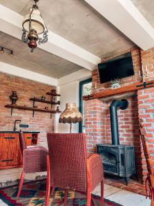 a living room with a brick fireplace and a stove at Villa Vejini in Mamkoda