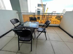 a table and chairs on a balcony with a view at Appleone Ayala Condo with Balcony in Cebu City