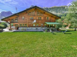 a log house with a green lawn in front of it at Chalet Le Grand-Bornand, 8 pièces, 11 personnes - FR-1-391-22 in Le Grand-Bornand