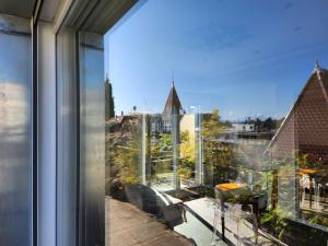 une fenêtre d'un bâtiment avec vue sur la ville dans l'établissement L'Orangerie, à Strasbourg