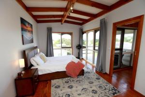 a bedroom with a bed in a room with windows at Tequila Sunset Beachfront Family Holiday Home, Bass Coast in Grantville