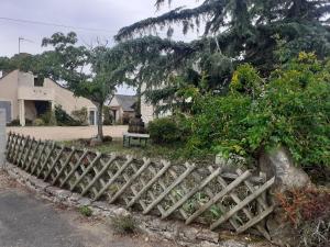 a wooden fence in front of a house at Maison à la campagne - piscine in Beaulieu-sur-Layon