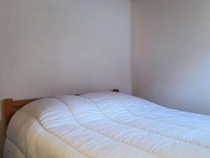 un letto bianco in un angolo di una stanza di Appartement Cauterets, 3 pièces, 5 personnes - FR-1-401-228 a Cauterets