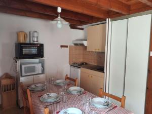 una cocina con una mesa con platos. en Appartement Cauterets, 3 pièces, 5 personnes - FR-1-401-228, en Cauterets