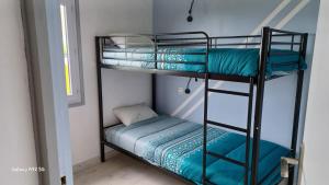 2 Etagenbetten in einem Zimmer mit einem kleinen Bett in der Unterkunft La maison entre deux plages,vue sur mer classée 4 étoiles in Criel-sur-Mer