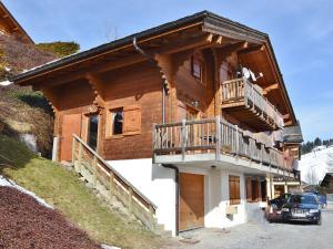 a log cabin with a balcony and a car parked outside at Chalet Le Grand-Bornand, 5 pièces, 8 personnes - FR-1-391-158 in Le Grand-Bornand