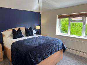 a bedroom with a large bed with a blue wall at Large 4 Bed, Central Oxford, Games Area, On-Site Parking in Oxford