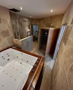 baño grande con bañera grande y lavamanos en Bella Notte Spa en Dijon