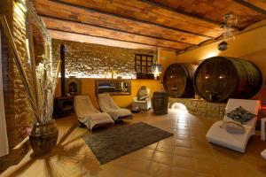 een woonkamer met stoelen en wijnvaten bij Borgo Dolci Colline Resort Granaio in Castiglion Fiorentino