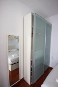 een slaapkamer met een glazen kast en een bed bij RentalSevilla Enjoy Seville in Sevilla