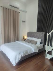 1 dormitorio con 1 cama grande con sábanas y almohadas blancas en Membunga Village, en Kota Bharu