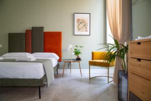 a hotel room with a bed and a chair at Palazzo Murat Luxury Rooms in Arienzo San Felice