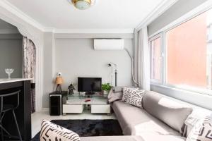 ein Wohnzimmer mit einem Sofa und einem TV in der Unterkunft Practical and Cozy Flat Near Taksim İstikal in Istanbul