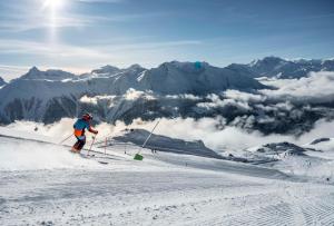 a man is skiing down a snow covered mountain at Dorothy Sunshine in Fiesch