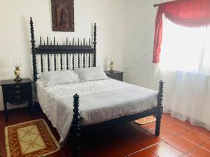 a bedroom with a bed and a window at Alfazema in São Sebastião