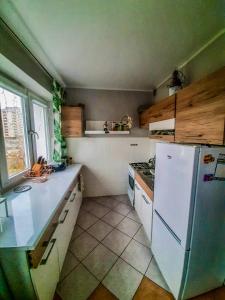 cocina con nevera blanca y fogones en Apartament by Wyszyńskiego Street en Konin