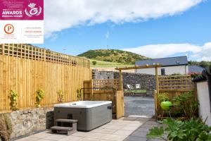 a backyard with a hot tub and a wooden fence at Luxury Couple's Retreat with Hot Tub at Lindores in Newburgh