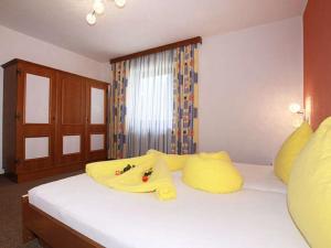 1 dormitorio con 1 cama grande con almohadas amarillas en Apartment Miramonte - KPL280 by Interhome, en Kappl