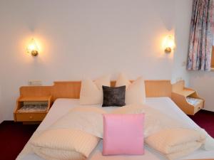 カップルにあるApartment Silvia - KPL160 by Interhomeのベッドルーム(ピンクの枕と白いベッド付)
