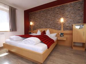 a bedroom with a large bed and a brick wall at Apartment Miramonte-2 by Interhome in Kappl