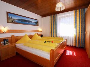 a bedroom with a bed with yellow sheets and a window at Apartment Miramonte-2 by Interhome in Kappl +16 photos