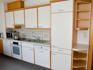 a kitchen with white cabinets and a sink at Apartment Niederhof by Interhome in Kappl