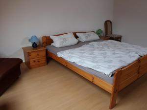 a bedroom with a bed with a wooden frame and a night stand at Apartment Am Pälitzsee-2 by Interhome in Strasen