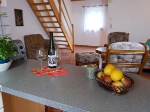 a bottle of wine and a basket of fruit on a counter at Apartment Am Pälitzsee-2 by Interhome in Strasen