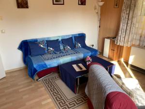 a living room with a blue couch and a table at Apartment Old Hüsung by Interhome in Mirow