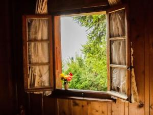 a window with a vase with flowers in it at Chalet La Pive by Interhome in Verbier