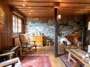 ein Wohnzimmer mit Stühlen und einer Steinmauer in der Unterkunft Chalet La Pive by Interhome in Verbier