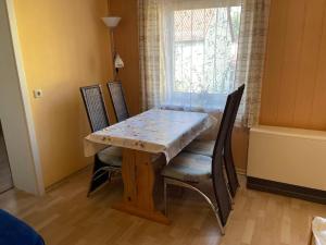 einen Esstisch mit Stühlen, einem Tisch und einem Fenster in der Unterkunft Apartment Old Hüsung - MUZ321 by Interhome in Mirow