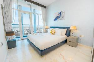 - une chambre avec un grand lit et une grande fenêtre dans l'établissement FAM Living - Bayz Tower by Danube - Business Bay, à Dubaï