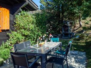 a dining table and chairs in a yard at Chalet Mustela by Interhome in Nendaz