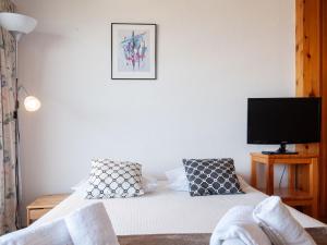 a bedroom with a bed with a tv on the wall at Apartment Christiania 1 P3 by Interhome in Nendaz