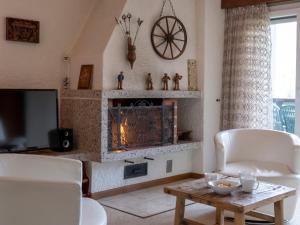 een woonkamer met een open haard en witte stoelen bij Apartment Les Girolles A59 by Interhome in Verbier