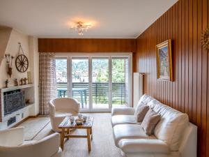 een woonkamer met een witte bank en stoelen bij Apartment Les Girolles A59 by Interhome in Verbier